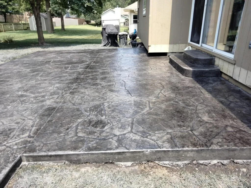 Stamped concrete patio with a flagstone pattern and matching steps, installed by MrImproveIt Remodeling in Mission, KS