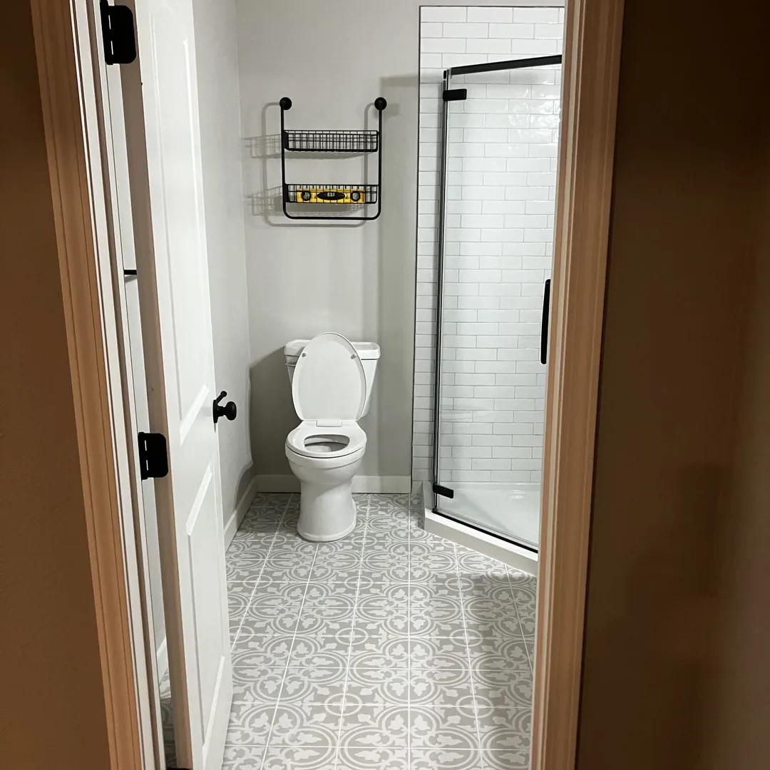 Bathroom remodel with patterned tile floor and glass shower enclosure by MrImproveIt